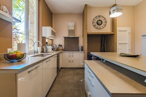 A modern kitchen with a built-in oven, a large window, and a clock on the wall.