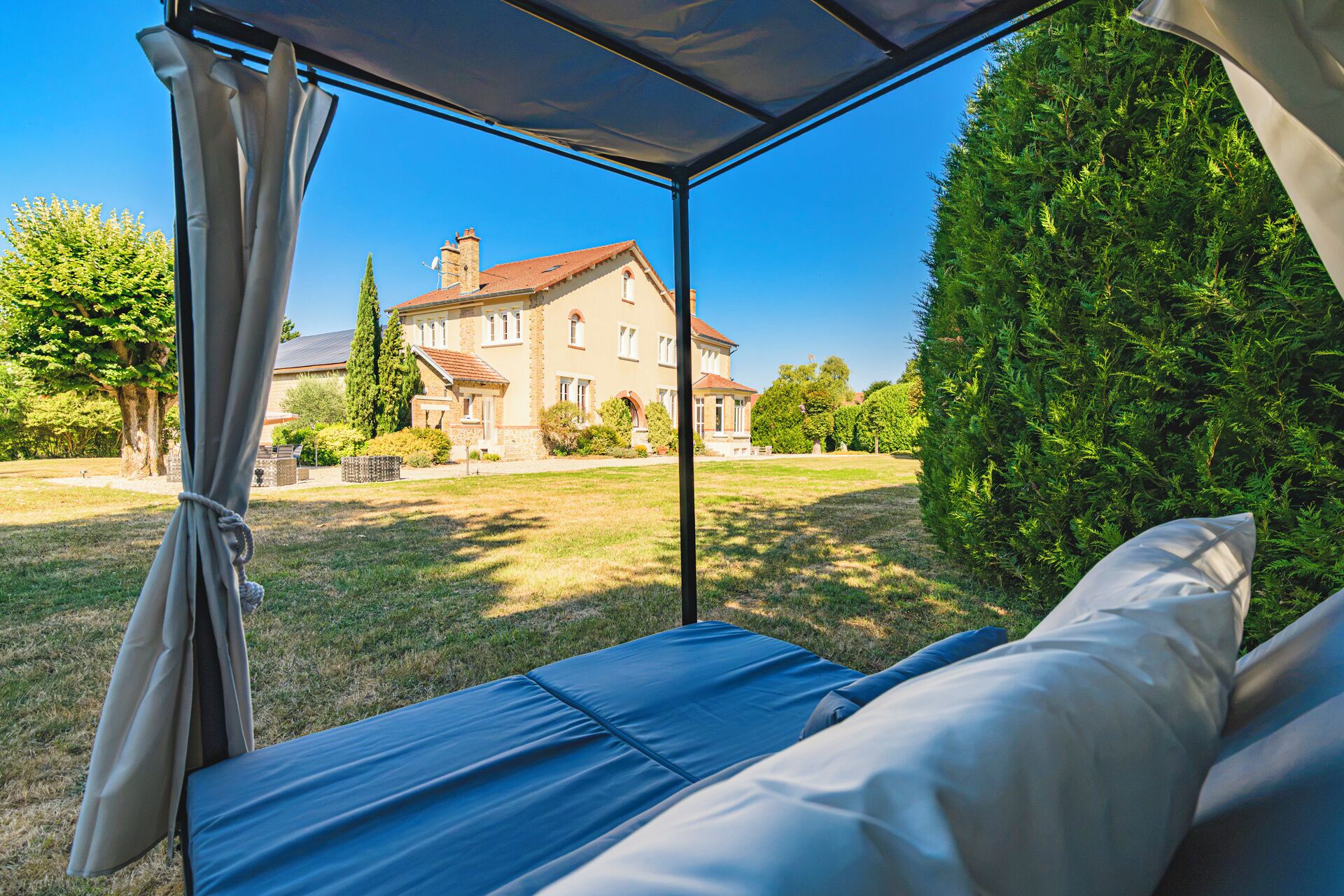 Una carpa con vista a una casa y un césped cuidado.