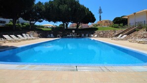 Una piscina con sillones de descanso y un cartel que dice "D'Alma Portuguesa".