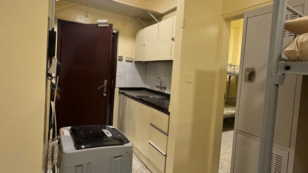 Cocina compacta con lavadora, refrigerador y lavamanos.