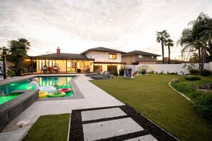 Une maison moderne dotée d’une piscine, d’une pelouse bien entretenue et d’un espace patio.