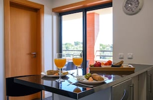 Uma mesa de café da manhã com suco de laranja, torradas e frutas.