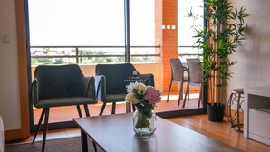 Een kamer met een houten tafel, twee stoelen, een vaas met bloemen en een potplant.
