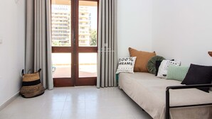 A room with a bed, a window with curtains, a door, and a view of a building outside. - Apart Marina Boat View D`alma Portuguesa (Loulé)