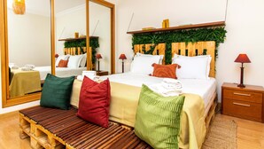 Een slaapkamer met een bed, nachtkastjes, een spiegel en een houten bankje.