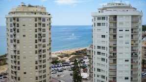 Ein Hochhaus mit Blick auf das Meer und einen Strand.