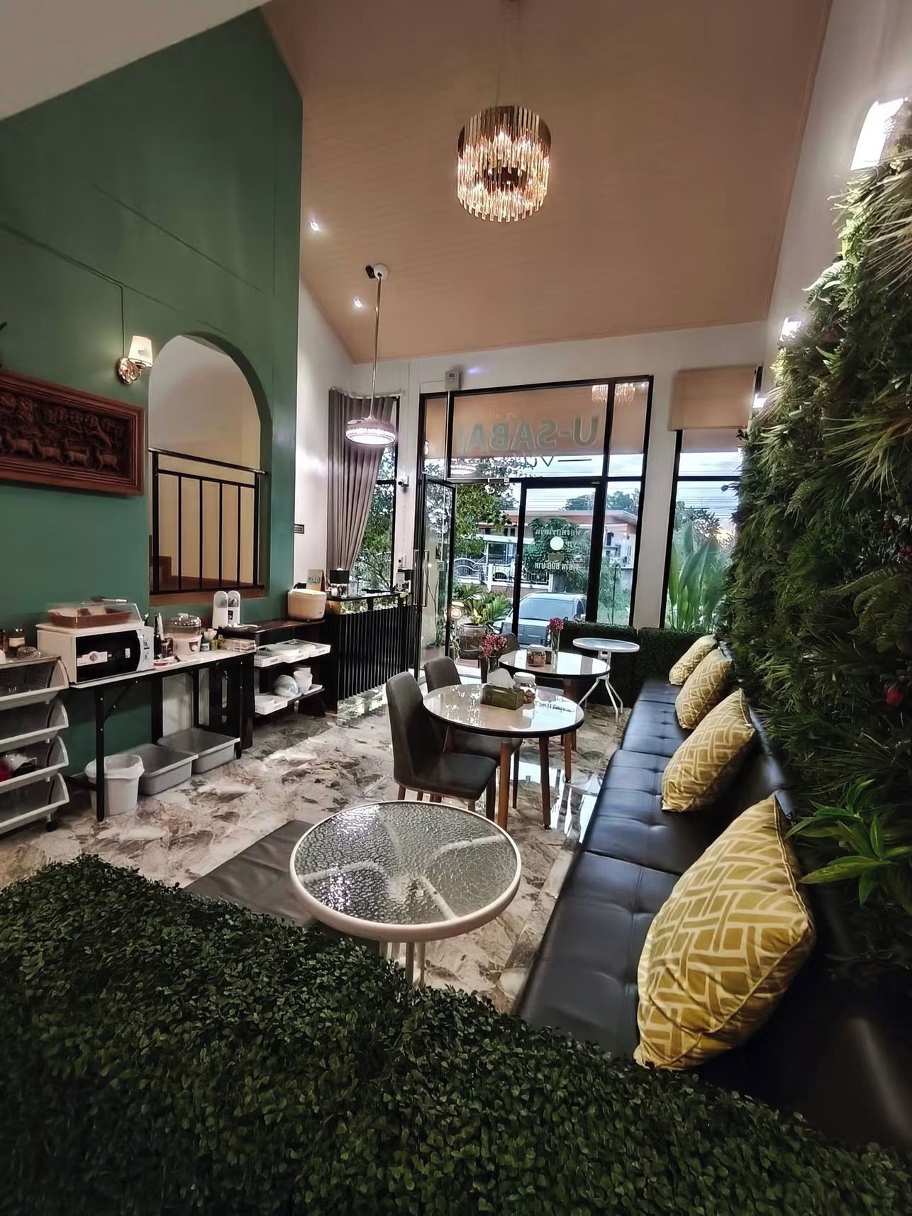 A modern interior with a seating area, tables, and a green wall.