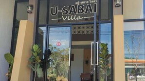 The entrance to U-Sabai Villa with a glass door, potted plants on either side, and a patterned tile staircase leading up to the entrance. - U-SABAI VILLA  (Yasothon)