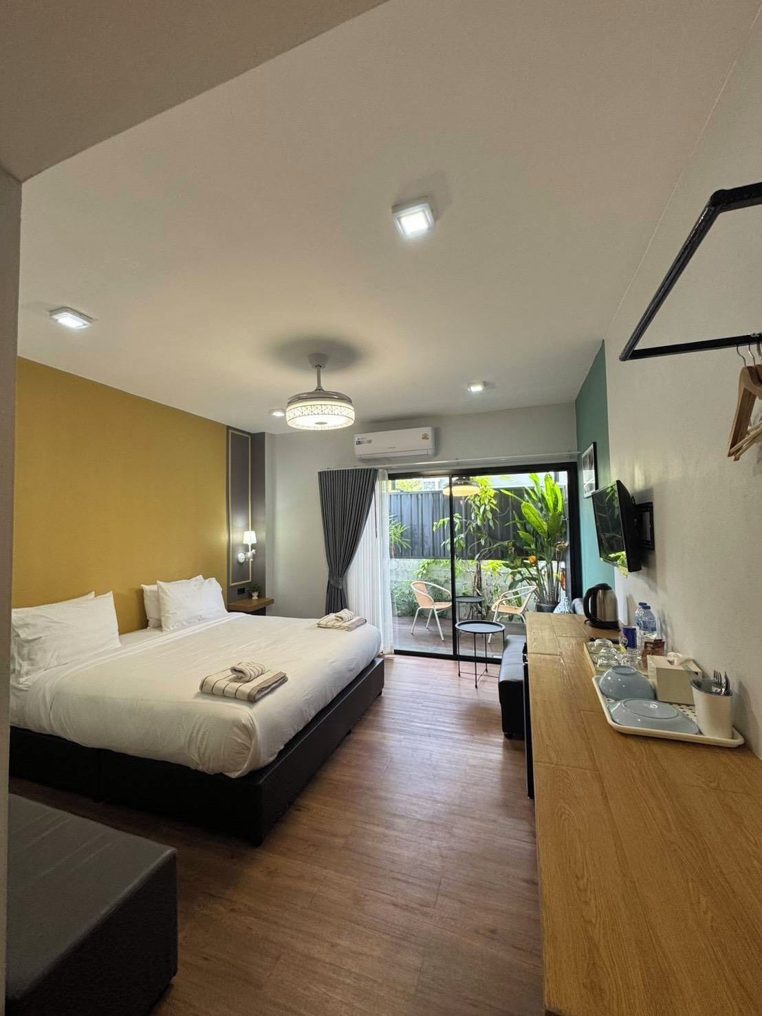 Habitación de hotel con cama, mesita de noche y vistas al exterior.