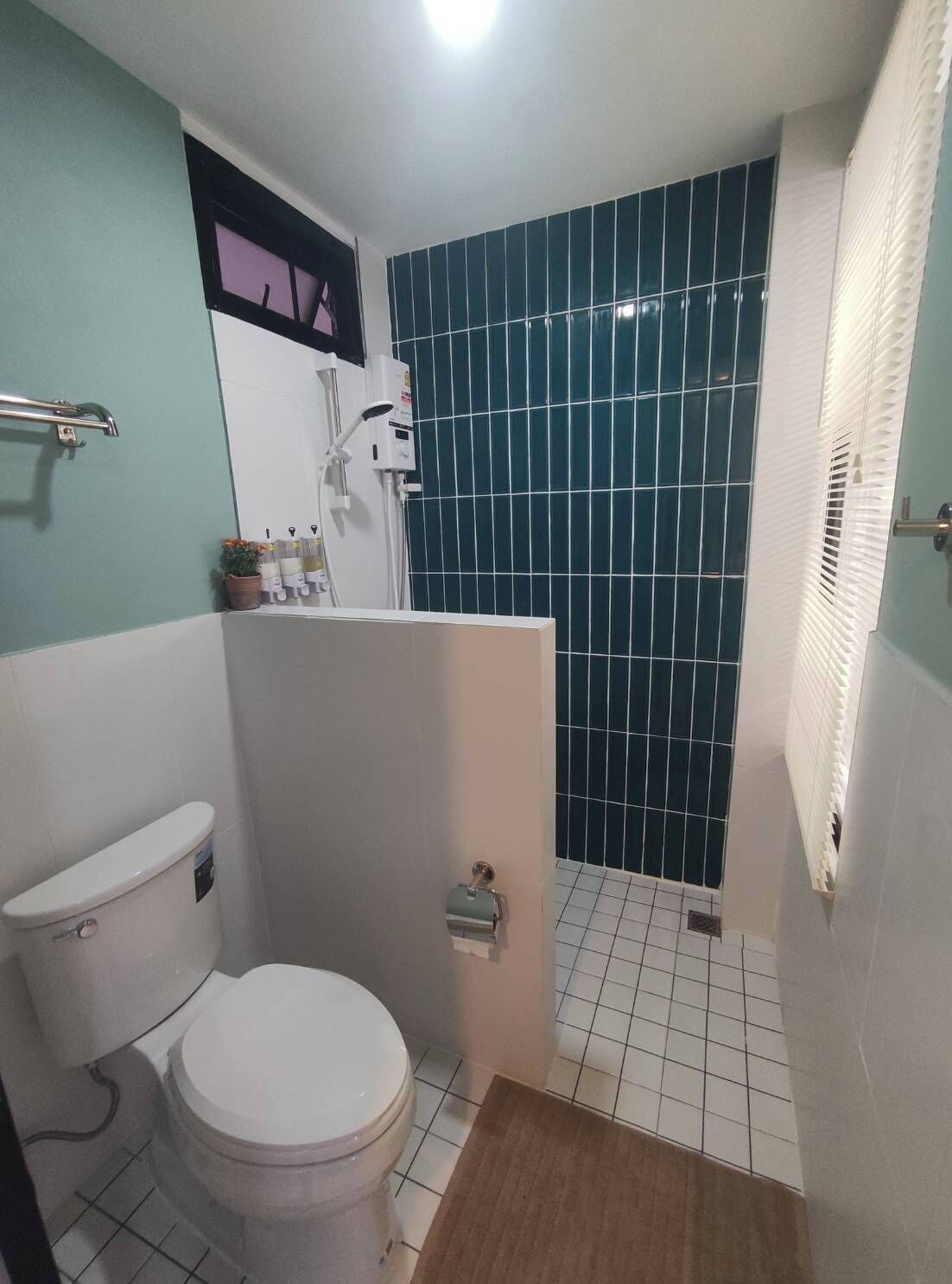 A small bathroom with a toilet, a shower, and a sink.