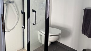 A modern bathroom with a glass-enclosed shower, a toilet, and a sink. - Seaside house Loctudy (Loctudy)