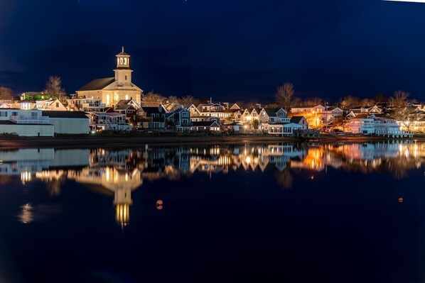A waterfront town with a prominent church and residential buildings reflecting on the water. - Private Deck, Parking, Walk to Town! (Provincetown)
