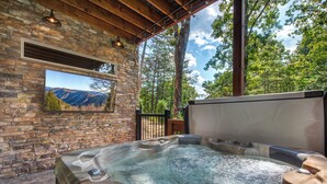 Ein Whirlpool mit Steinwand und Bergblick.
