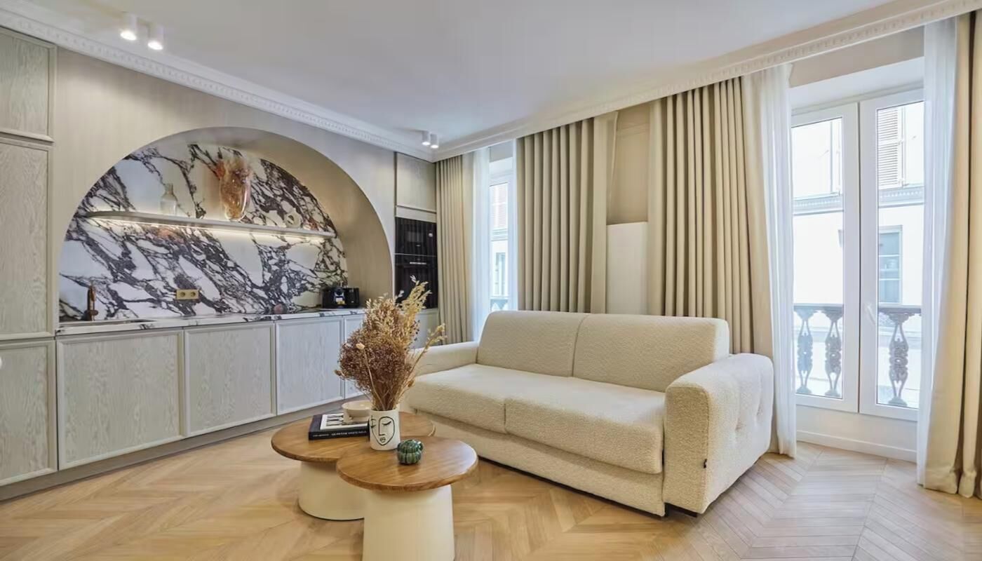 A modern living room with a sofa, a coffee table, and a decorative wall piece.