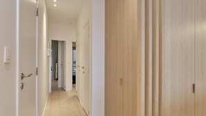A hallway with wooden flooring and white walls, leading to a room with a door. - Flat in Blankenberge Near Belgium Pier (Blankenberge)