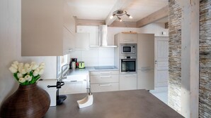 Eine moderne Küche mit weißen Schränken, einer Mikrowelle, einem Backofen und einer Wand mit Steinakzenten.
