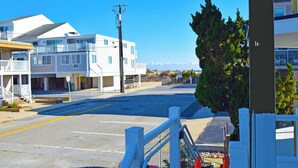 A coastal street with white buildings, a clear sky, and a view of the ocean. - Coral Ridge 1-Oceanside 78th St, Free WiFi, W/D, AC (Ocean City)