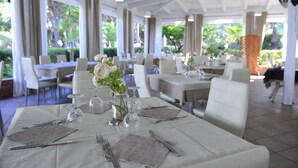 A restaurant with tables set for dining, featuring white tablecloths, silverware, and glassware. - ITALY VILLAGE (Sessa Aurunca)