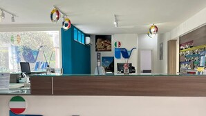 A reception desk with the sign "Italy Village" and a logo featuring a stylized map of Italy. - ITALY VILLAGE (Sessa Aurunca)