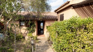 A traditional building with a tiled roof, a wooden door, and a stone pathway leading to the entrance.