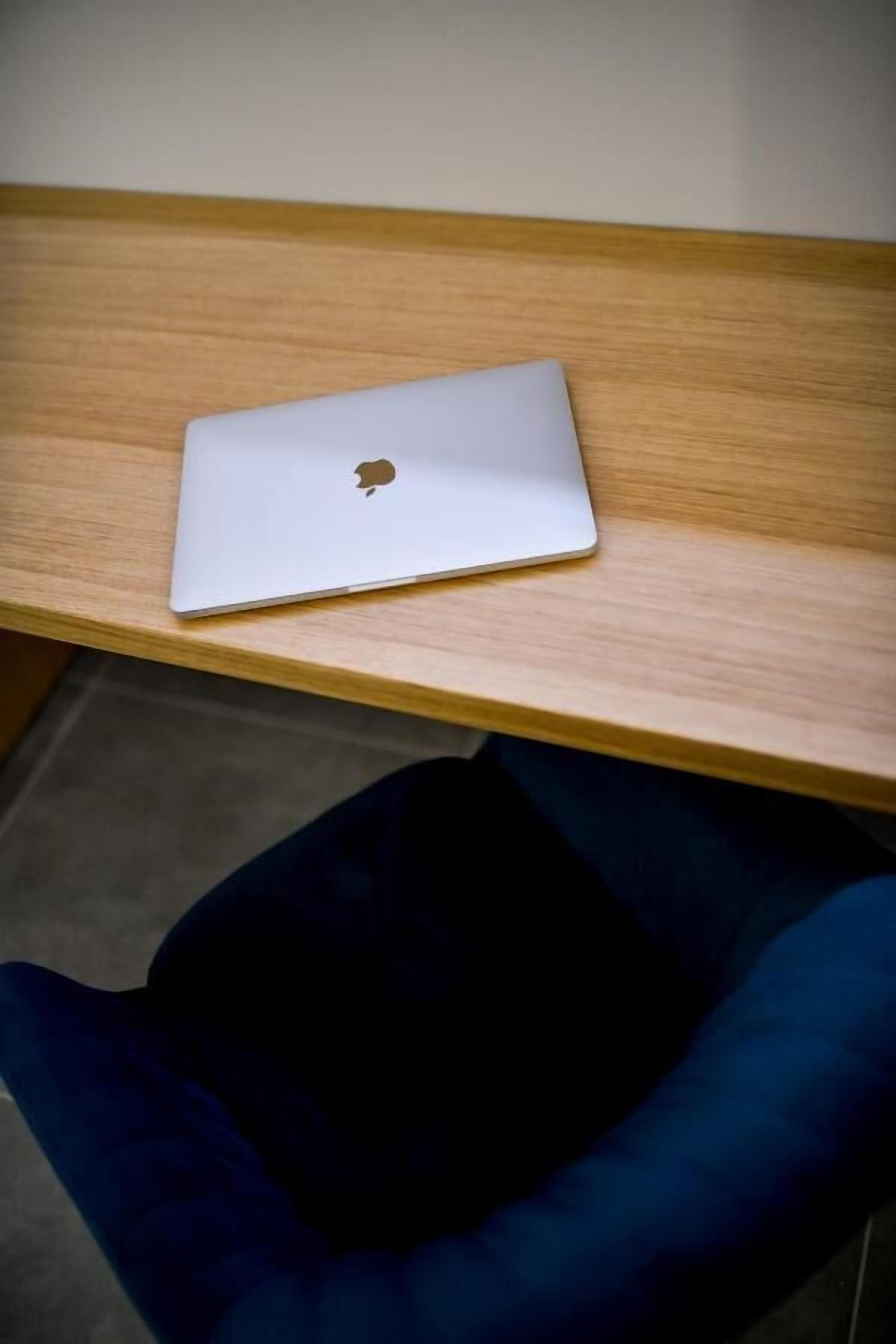A laptop on a wooden desk.