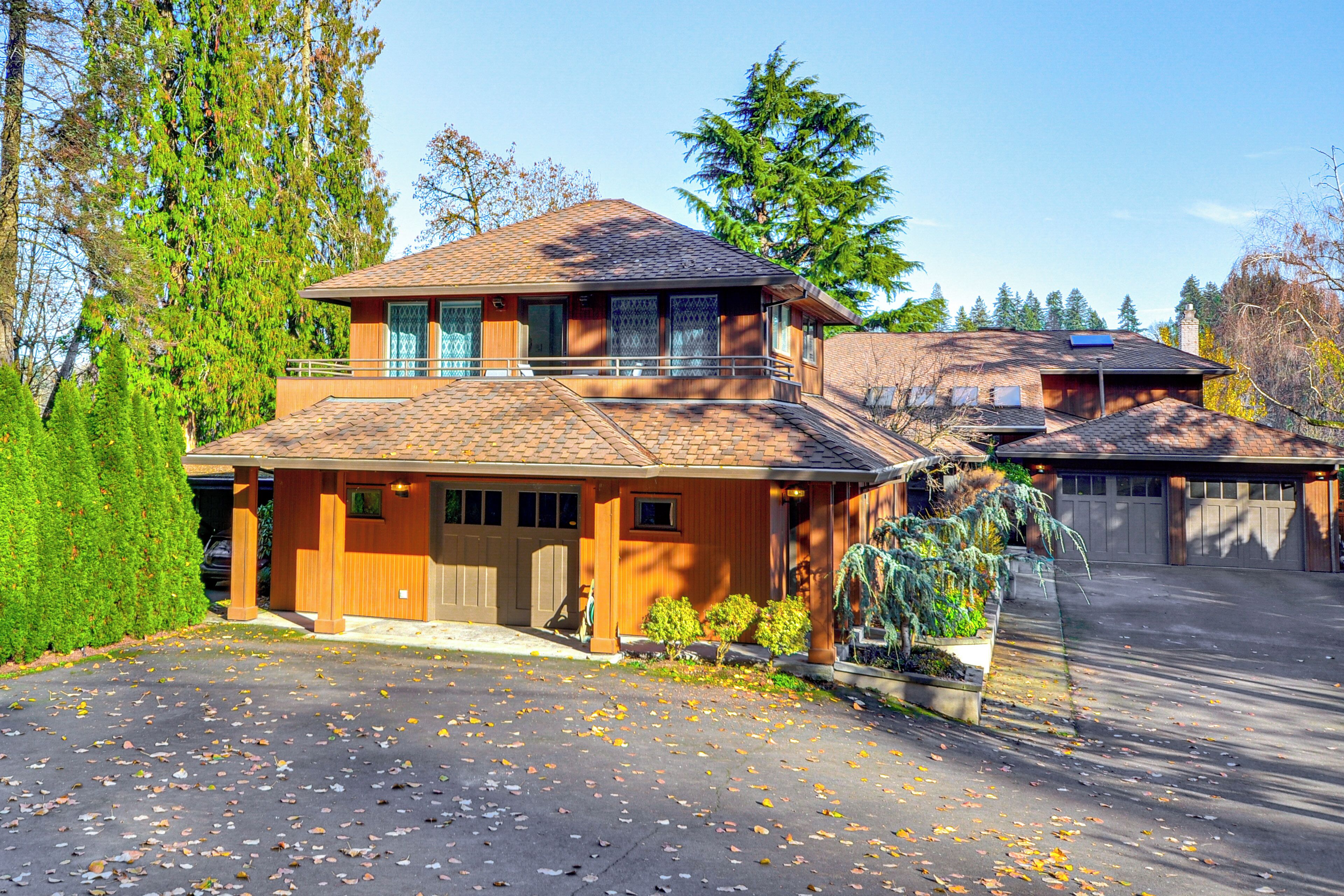 Une maison à deux étages avec un garage, une allée couverte et une pelouse bien entretenue.