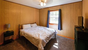 A bedroom with a bed, a nightstand, a dresser, a ceiling fan, and a window with curtains. - Game Room! Serene 15-acre Nature Escape in Delmar (Delmar)