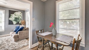 A dining area with a wooden table, chairs, and a vase with flowers. - Near Sabine Lake & Refineries: Pet-friendly Apt (Port Arthur)