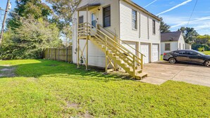 A two-story house with a front porch, a staircase, and a garage. - Near Sabine Lake & Refineries: Pet-friendly Apt (Port Arthur)