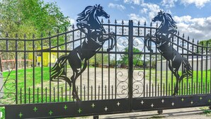 A metal gate with decorative horse figures. - Family Home on 30 Acres in Manvel! (Manvel)