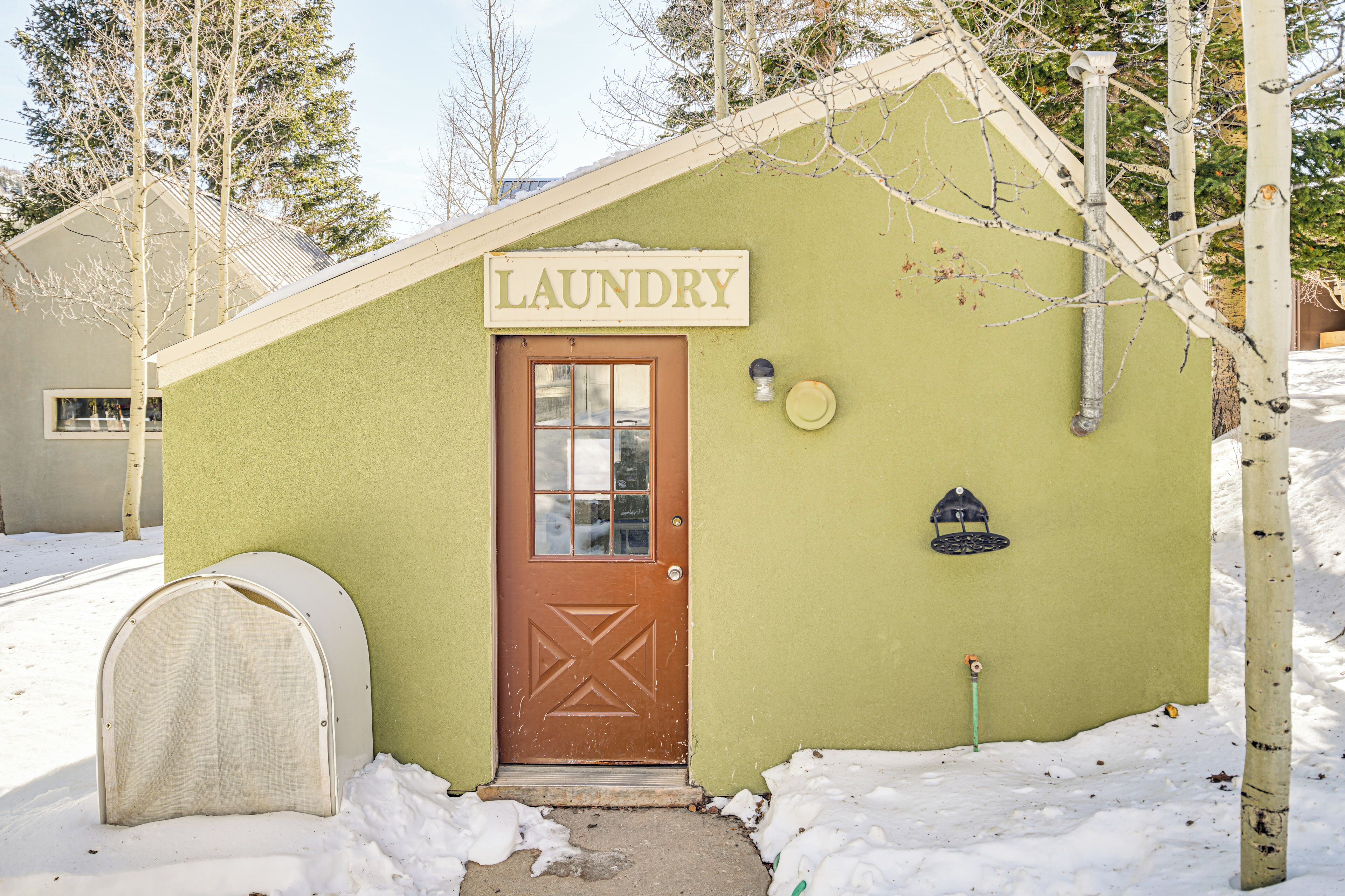 A small laundry facility with a brown door and a sign that reads "LAUNDRY".
