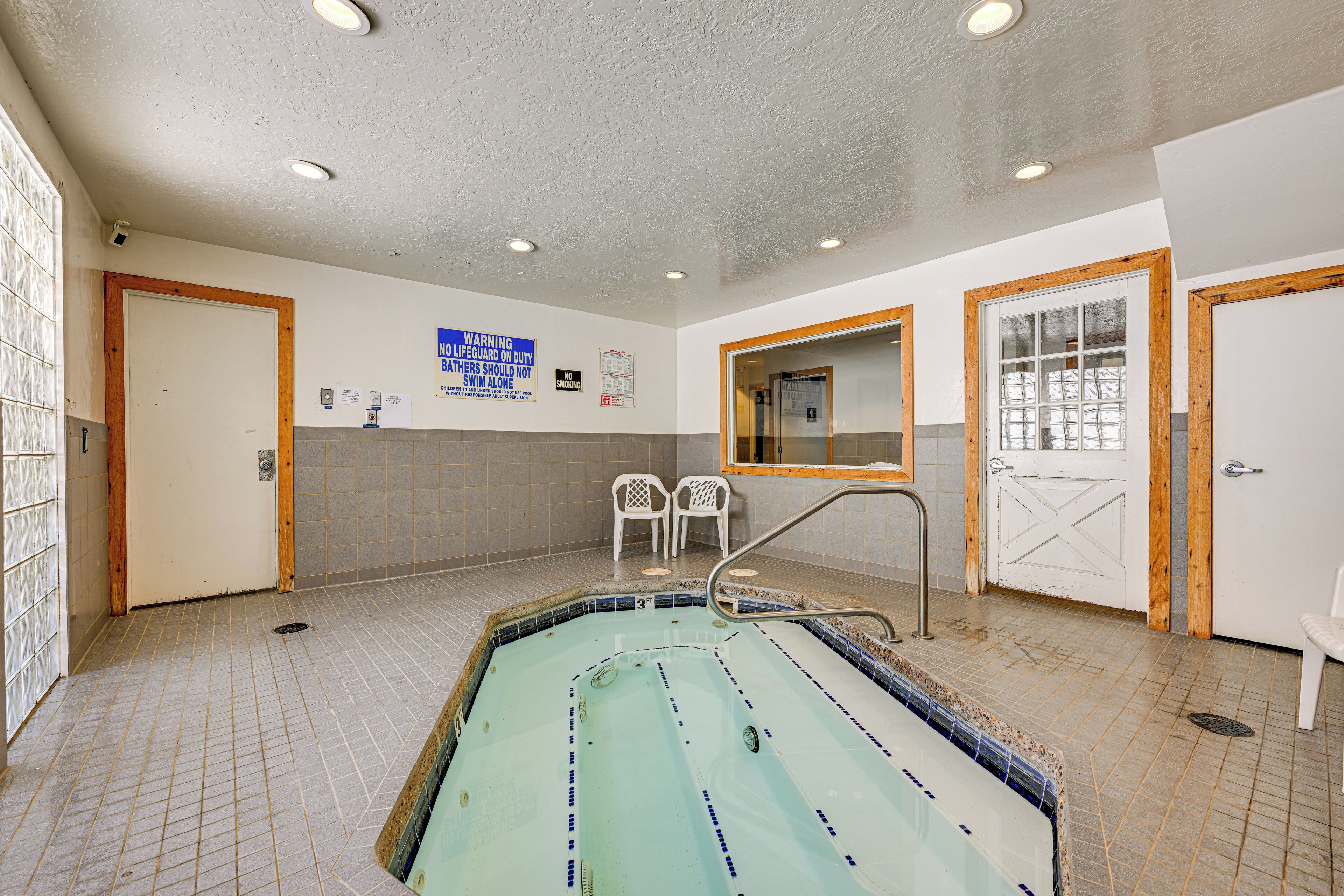Une piscine dont les murs sont recouverts de carreaux et dont le plafond est doté d’un éclairage encastré.