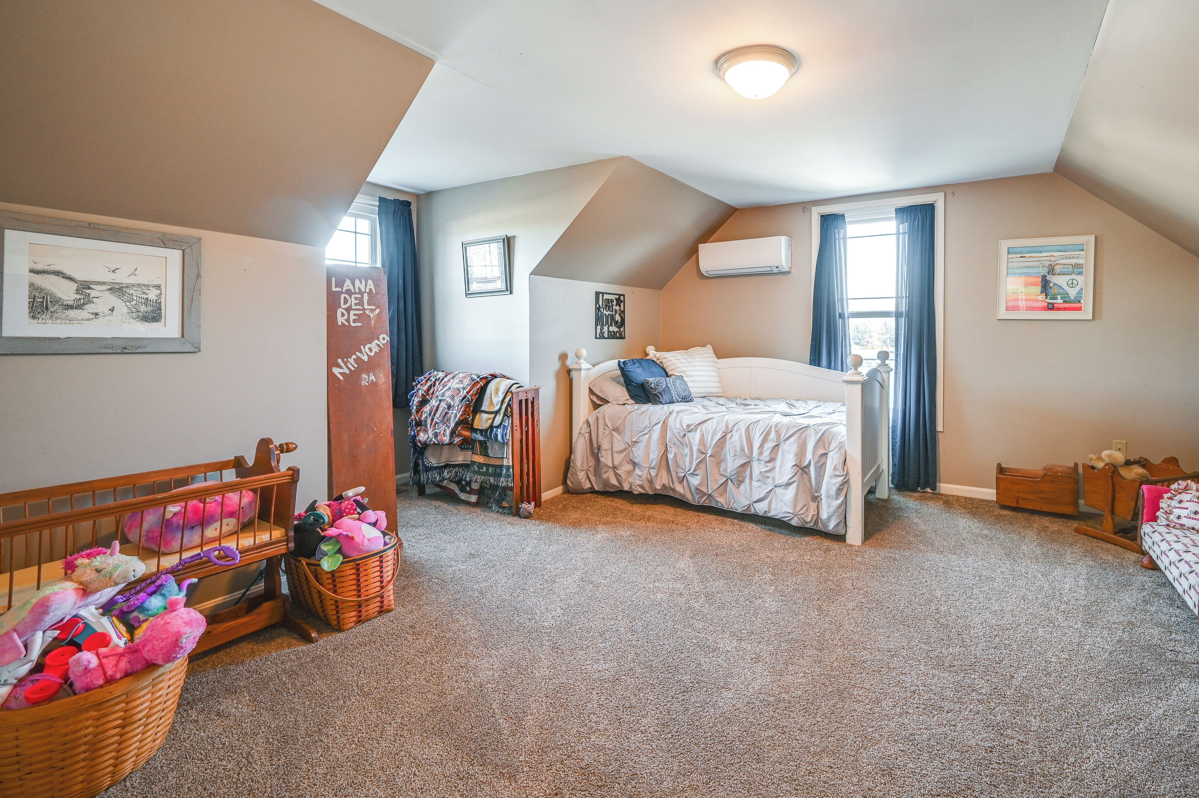 A cozy bedroom with a bed, a crib, and a dresser.