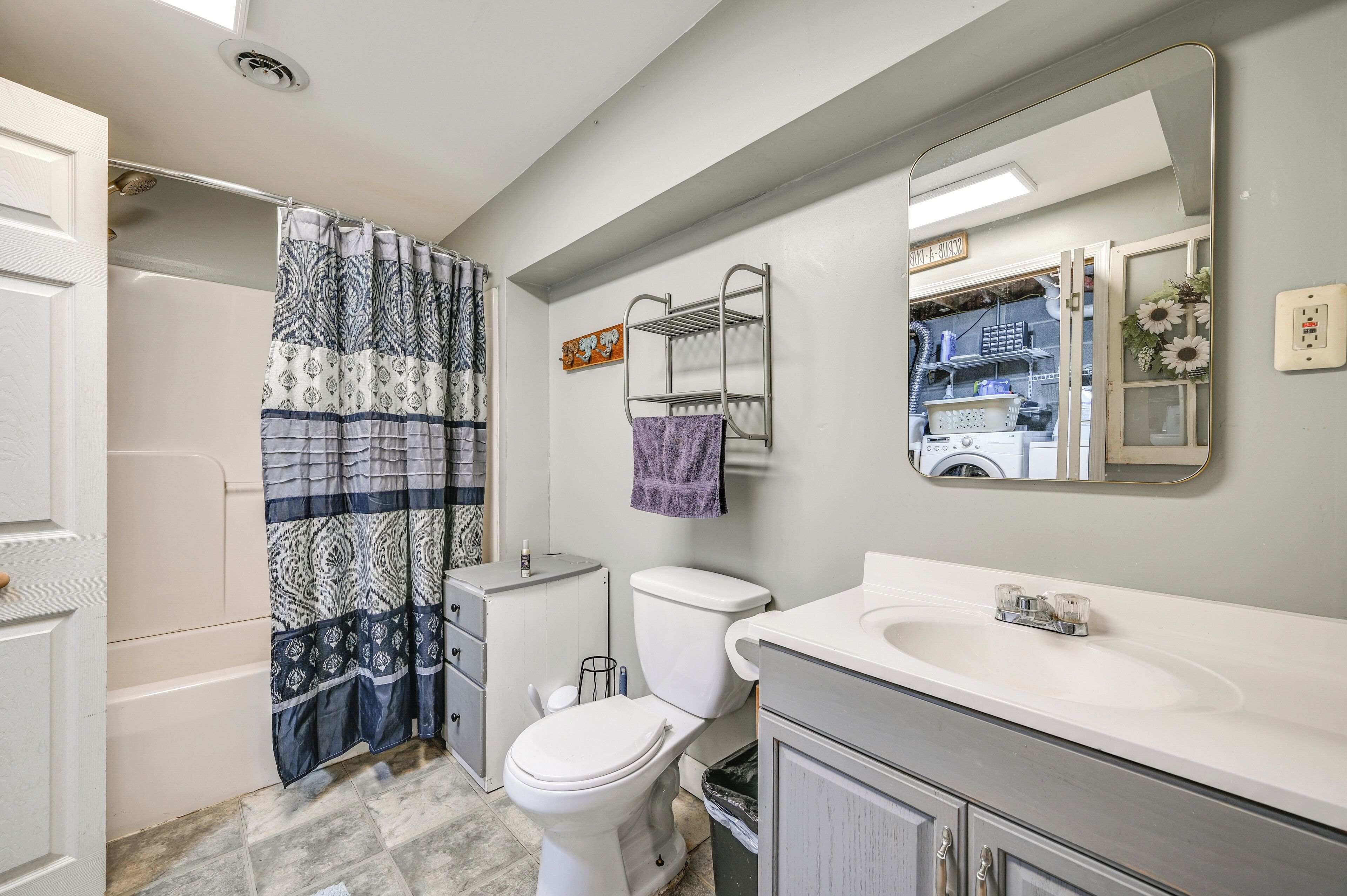 A bathroom with a toilet, sink, and shower curtain.