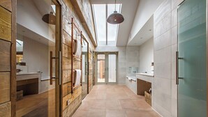 A modern kitchen with wooden cabinetry, a skylight, and a view to the outside. - The Pigs (Melton Constable)