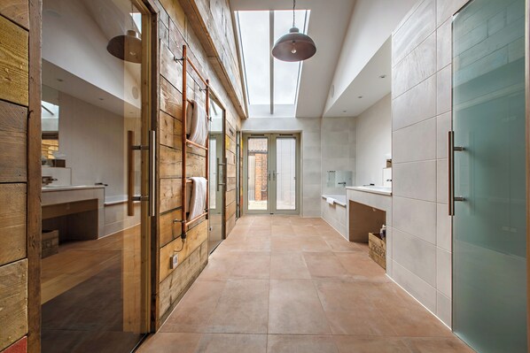 A modern kitchen with wooden cabinetry, a skylight, and a view to the outside. - The Pigs (Melton Constable)