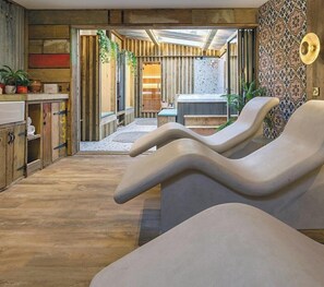 A spa area with wooden flooring, a reception desk, and a wall with patterned tiles. - The Pigs (Melton Constable)
