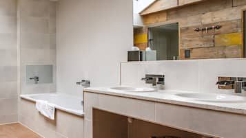 Een moderne badkamer met twee wastafels, een grote spiegel en een houten kratje met de tekst 'PIGSPA' onder het aanrecht.