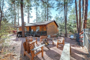 A cabin with a deck, surrounded by tall pine trees. - Deck & Forest Views: Black Bear Cabin' in Payson (Payson)