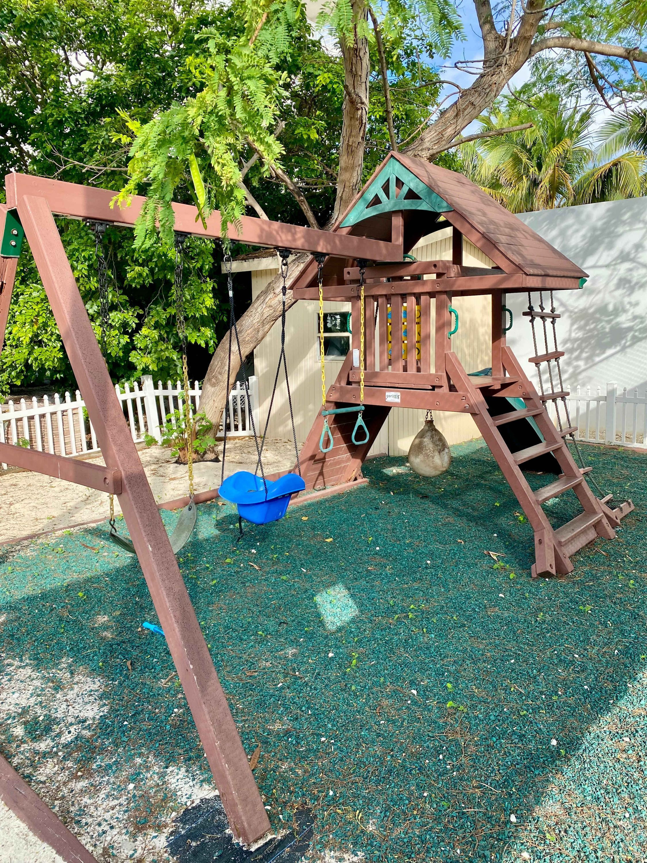 Une aire de jeux avec des balançoires et une structure d’escalade.
