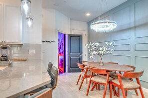 A modern kitchen with a marble countertop, a built-in blender, and a dining area with a wooden table and chairs. - Amazing 5BD Family Townhouse at Paradiso Grande (Orlando)