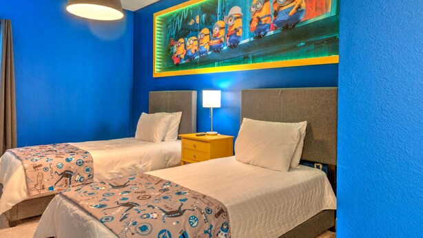 A hotel room with two beds, a large mural of minions, a lamp, and a ceiling light. - Amazing 5BD Family Townhouse at Paradiso Grande (Orlando)