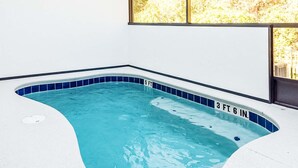 A small indoor swimming pool with blue tiles and depth markers.