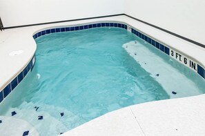 A small indoor swimming pool with a blue tiled edge and a white deck surrounding it. - Amazing 5BD Family Townhouse at Paradiso Grande (Orlando)