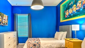 A room with a bed, bedside table, dresser, and a window with blinds.
