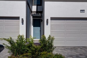 A modern two-car garage with a blue door and a number plate. - Amazing 5BD Family Townhouse at Paradiso Grande (Orlando)