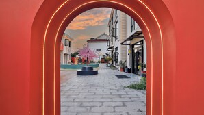 A pathway leading through a red archway with a cherry blossom tree in the center. - Xiangyun Qinzi hotel (Shanghai)