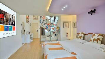 A modern hotel room with a large bed, a desk, and a mirror.