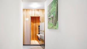 A hallway with a wooden door leading to a room with a bed and a small table. - Summio Bungalowpark De Riethorst (Plasmolen)