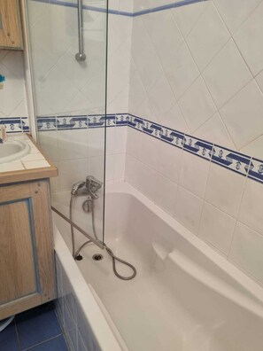 A bathroom with a bathtub, a shower, and a sink. - Very nice apartment for 4 people, 2 bedrooms, beautiful living room and terrace. (Cavalaire-sur-Mer)